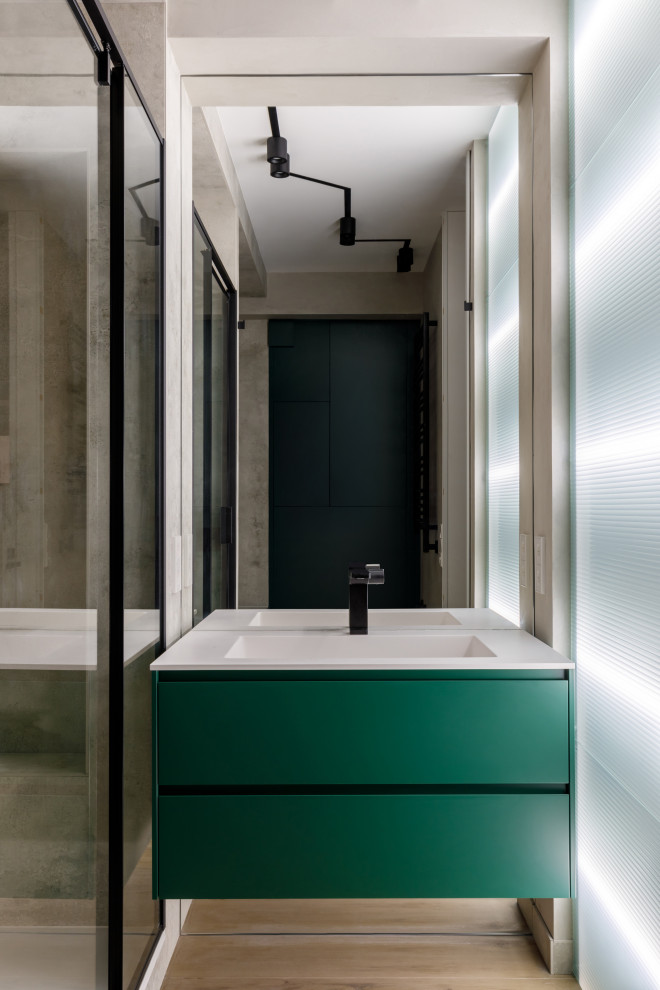 This is an example of a mid-sized contemporary master bathroom in Moscow with green cabinets, an alcove tub, an alcove shower, a wall-mount toilet, brown tile, porcelain tile, brown walls, porcelain floors, a wall-mount sink, engineered quartz benchtops, brown floor, a hinged shower door, white benchtops, a single vanity, a floating vanity and panelled walls.