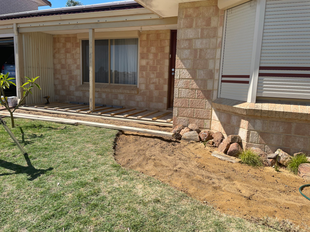This is an example of a mid-sized modern side yard and ground level deck in Perth.
