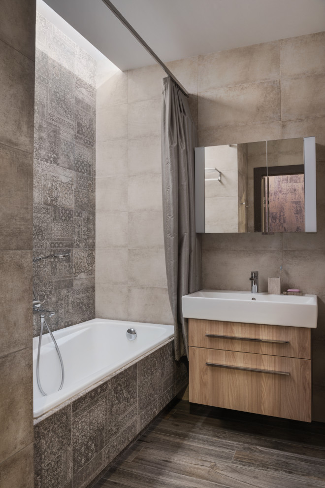 Idéer för att renovera ett mellanstort nordiskt en-suite badrum, med släta luckor, skåp i ljust trä, ett undermonterat badkar, en dusch/badkar-kombination, en vägghängd toalettstol, brun kakel, keramikplattor, grå väggar, klinkergolv i porslin, ett nedsänkt handfat, brunt golv och dusch med duschdraperi