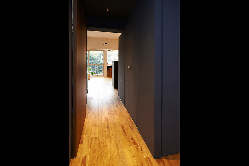 Design ideas for a mid-sized midcentury hallway in Tokyo with white walls, medium hardwood floors and brown floor.