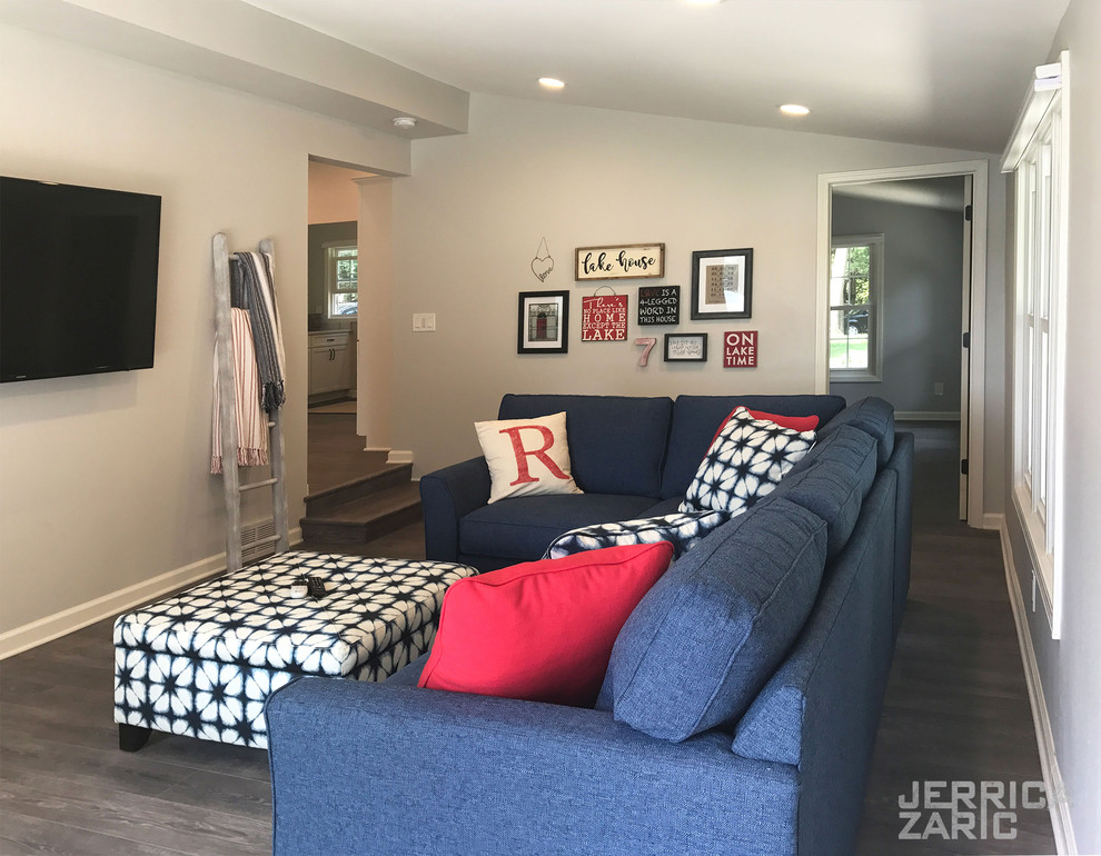 This is an example of a mid-sized beach style open concept living room with grey walls, a wall-mounted tv, grey floor, vinyl floors and no fireplace.
