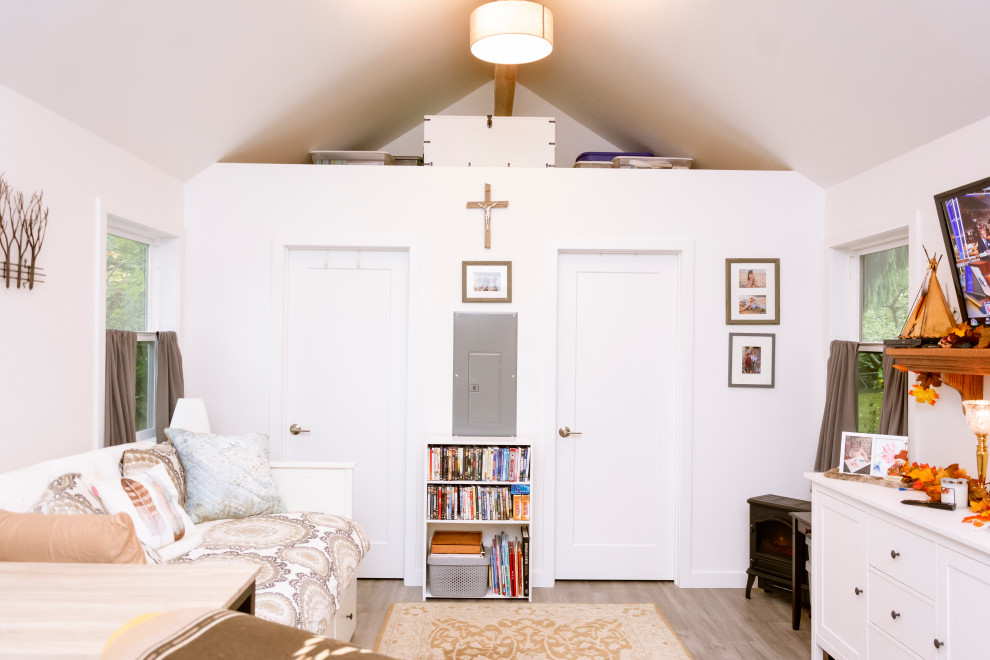 На фото: маленькая гостиная комната в стиле модернизм с белыми стенами и сводчатым потолком без камина для на участке и в саду
