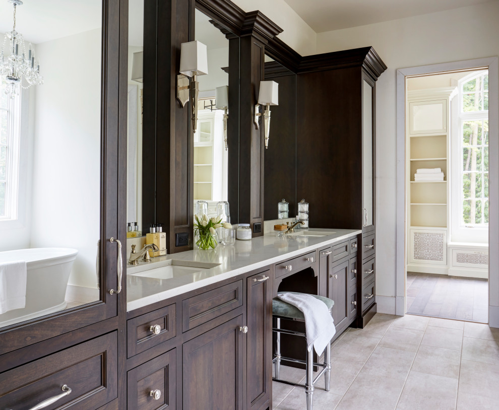 Bild på ett stort vintage beige beige en-suite badrum, med luckor med infälld panel, skåp i mörkt trä, ett fristående badkar, klinkergolv i porslin, ett undermonterad handfat, bänkskiva i kvarts och beiget golv