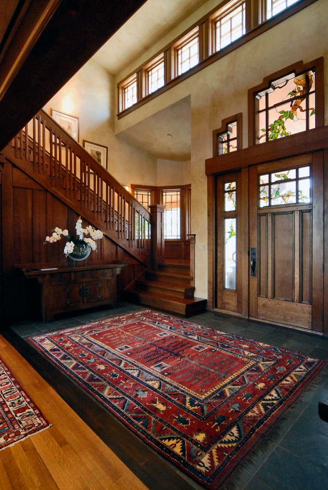 Inspiration for a large arts and crafts foyer in Denver with porcelain floors, a single front door and a dark wood front door.