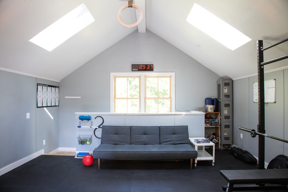 Photo of a large traditional home weight room in Philadelphia with blue walls and black floor.
