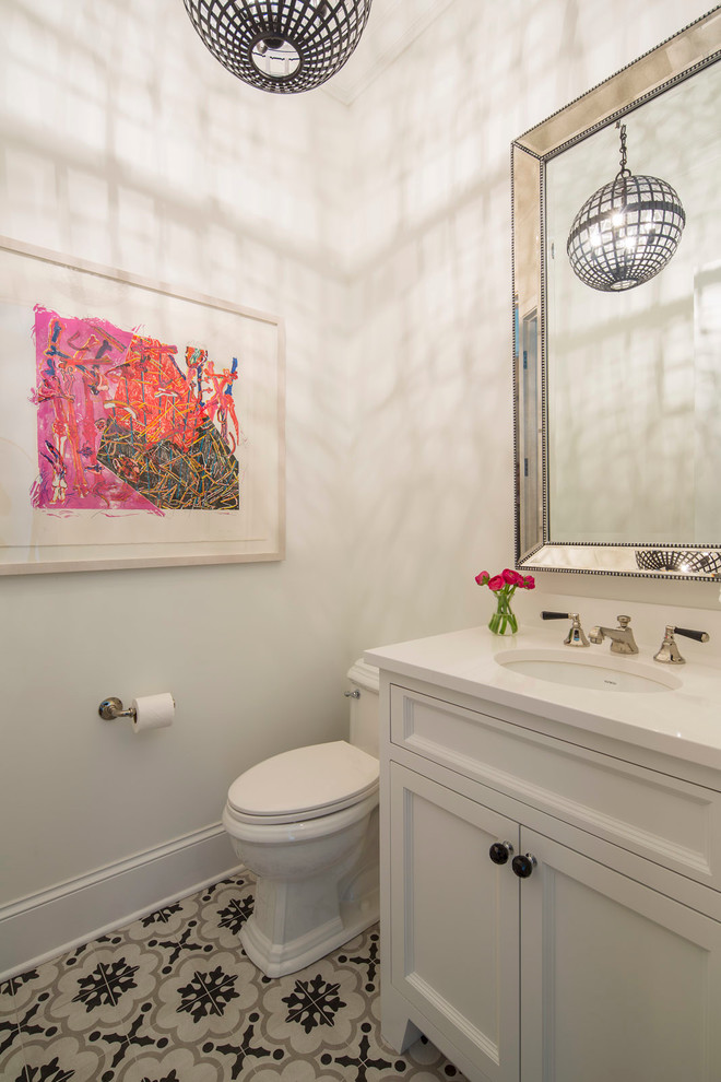 Photo of a mid-sized contemporary powder room in Minneapolis with shaker cabinets, white cabinets, a two-piece toilet, white walls, cement tiles, an undermount sink, multi-coloured floor and engineered quartz benchtops.