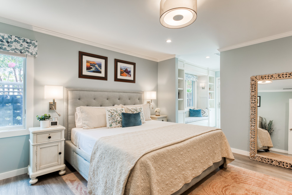 Diseño de dormitorio principal tradicional renovado de tamaño medio con paredes azules, suelo de madera en tonos medios y suelo gris