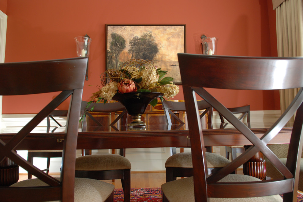 Photo of a mid-sized traditional separate dining room in Other with red walls and light hardwood floors.