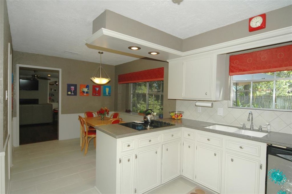Mid-sized transitional u-shaped porcelain tile eat-in kitchen photo in Houston with an undermount sink, recessed-panel cabinets, gray cabinets, solid surface countertops, white backsplash, ceramic backsplash, stainless steel appliances and no island