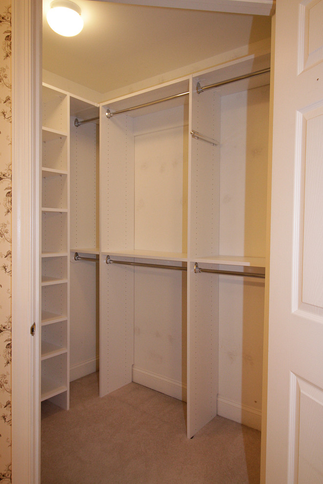 Small traditional women's walk-in wardrobe in New York with flat-panel cabinets, white cabinets and carpet.