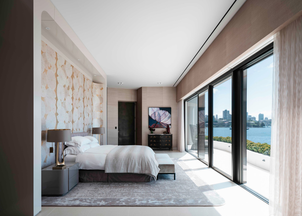 This is an example of a large modern master bedroom in Sydney with beige walls, ceramic flooring, a corner fireplace, a stone fireplace surround, beige floors and wallpapered walls.