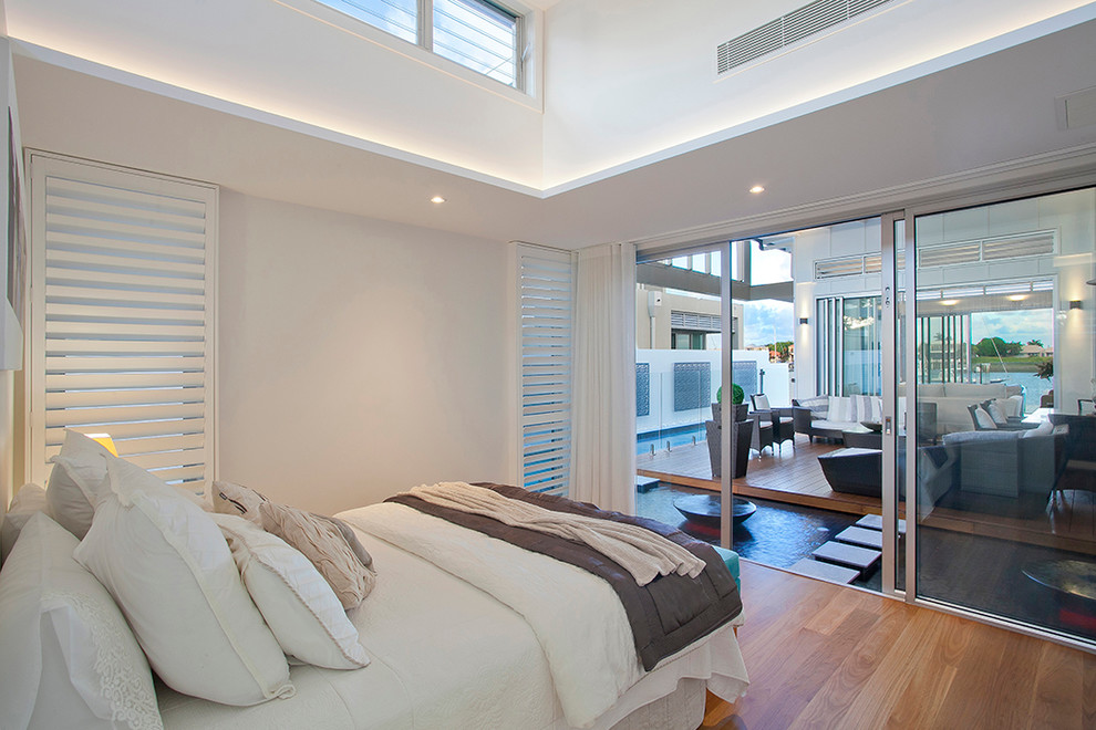 Design ideas for a contemporary bedroom in Sunshine Coast with white walls, medium hardwood floors and no fireplace.