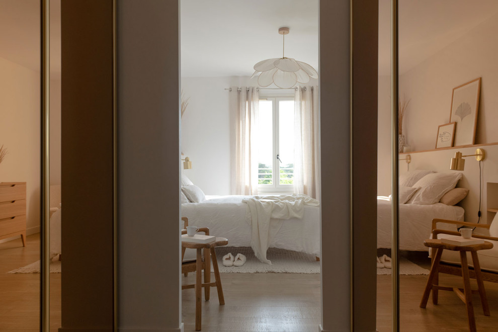 Cette image montre une grande chambre parentale blanche et bois nordique avec un mur blanc, parquet clair, du papier peint et dressing.