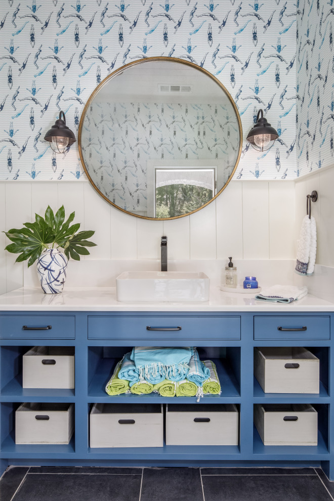 This is an example of a beach style bathroom in Atlanta with beaded inset cabinets, blue cabinets, white walls, a vessel sink, black floor and white benchtops.