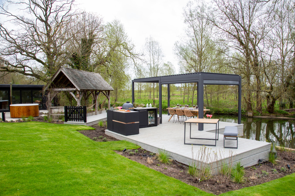 Inspiration for a small contemporary back patio in Essex with an outdoor kitchen, decking and a pergola.