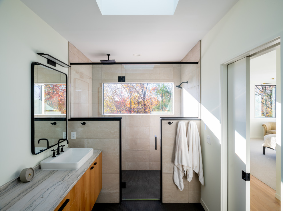 Modernes Duschbad mit flächenbündigen Schrankfronten, hellbraunen Holzschränken, Duschnische, Marmor-Waschbecken/Waschtisch, Falttür-Duschabtrennung, Einzelwaschbecken, schwebendem Waschtisch, beigen Fliesen, weißer Wandfarbe, Mosaik-Bodenfliesen, schwarzem Boden und bunter Waschtischplatte in Minneapolis