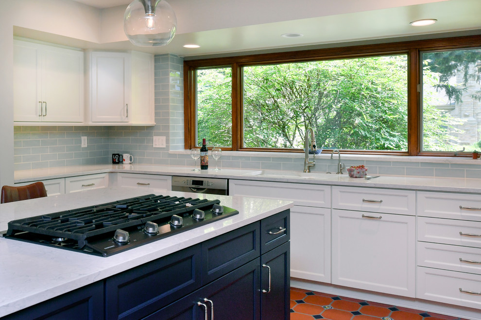 Large transitional u-shaped porcelain tile and orange floor eat-in kitchen photo with a double-bowl sink, recessed-panel cabinets, white cabinets, quartz countertops, blue backsplash, subway tile backsplash, stainless steel appliances, an island and gray countertops