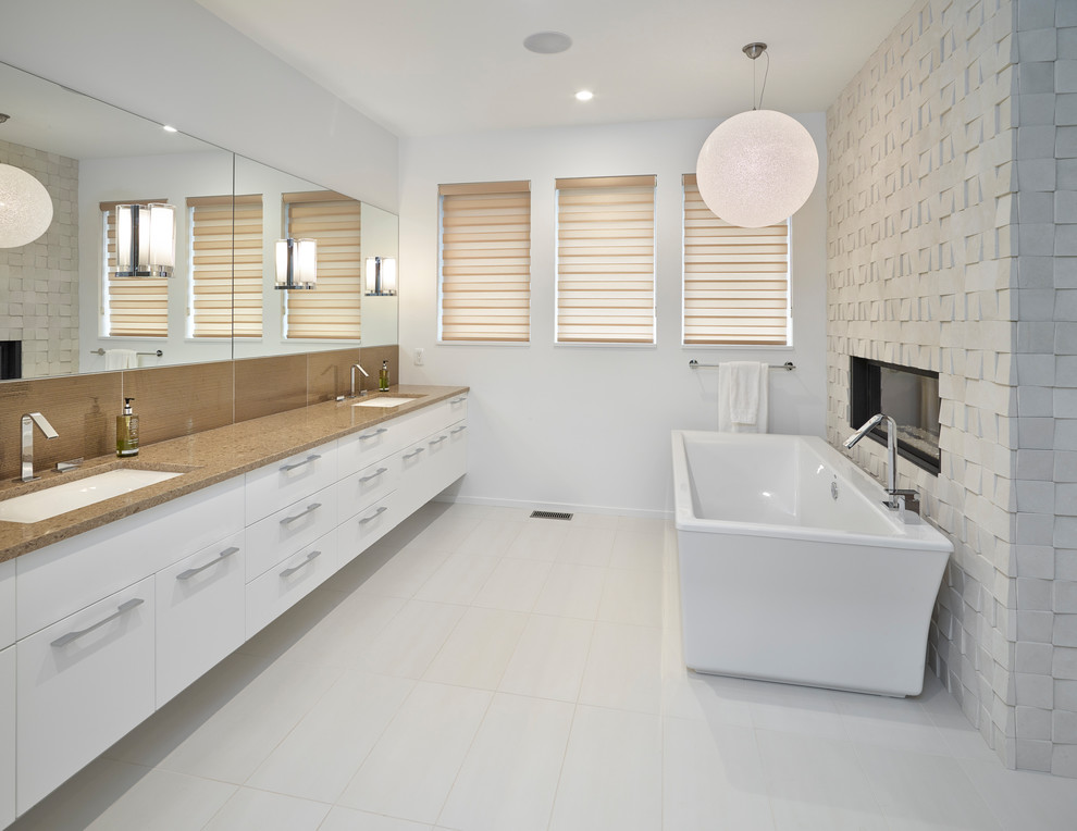 Large master white tile porcelain tile and white floor freestanding bathtub photo in Edmonton with flat-panel cabinets, white cabinets, an undermount sink, quartz countertops and beige countertops