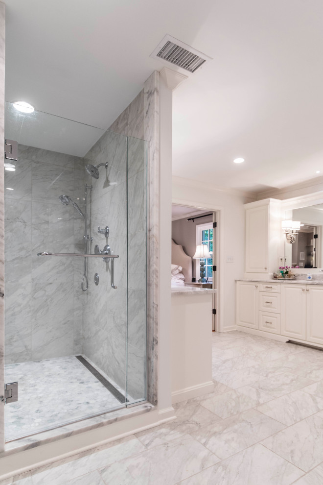 Inspiration for a large transitional master bathroom in Indianapolis with raised-panel cabinets, white cabinets, an undermount tub, an alcove shower, gray tile, ceramic tile, white walls, ceramic floors, an undermount sink, marble benchtops, multi-coloured floor, a hinged shower door and white benchtops.