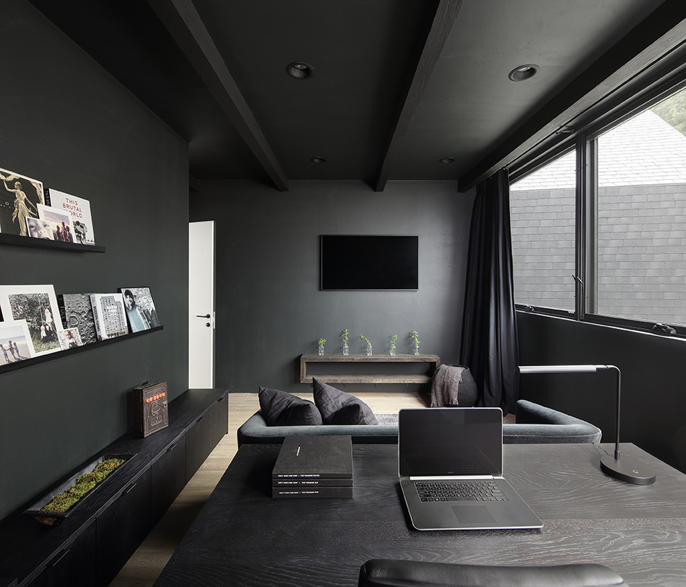Example of a minimalist light wood floor home office design in Milwaukee with black walls