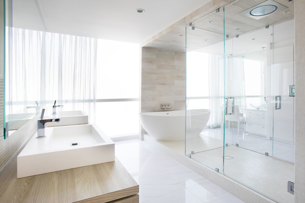 Large modern master bathroom in Atlanta with flat-panel cabinets, light wood cabinets, a freestanding tub, a curbless shower, stone tile, white walls, marble floors, a vessel sink, laminate benchtops, white floor and a hinged shower door.