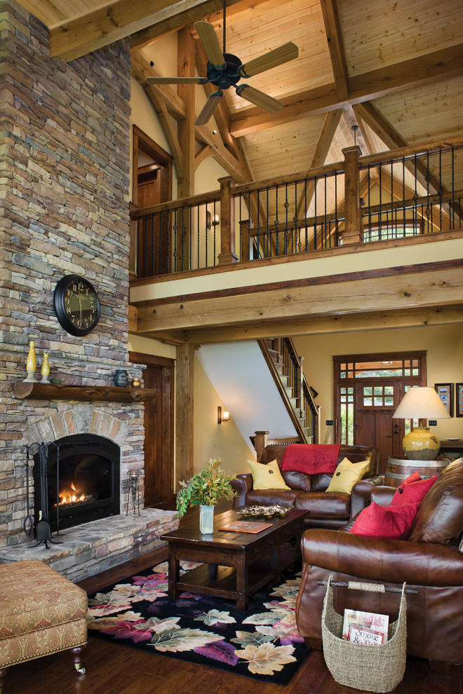Photo of a mid-sized country open concept living room in Other with a standard fireplace, a stone fireplace surround, beige walls, dark hardwood floors and no tv.