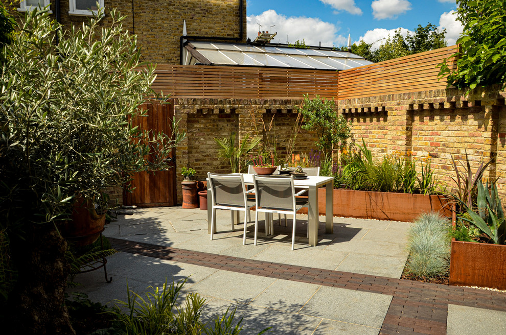 Design ideas for a small contemporary backyard patio in London.