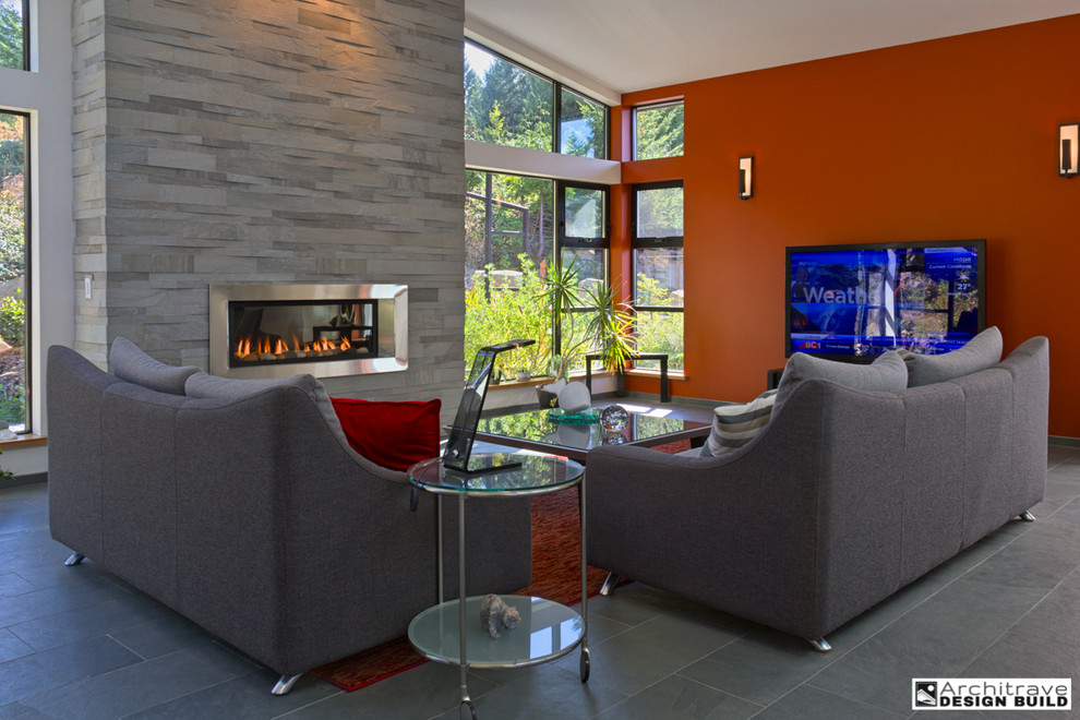 Mid-sized contemporary home theatre in Vancouver with multi-coloured walls, slate floors and a wall-mounted tv.