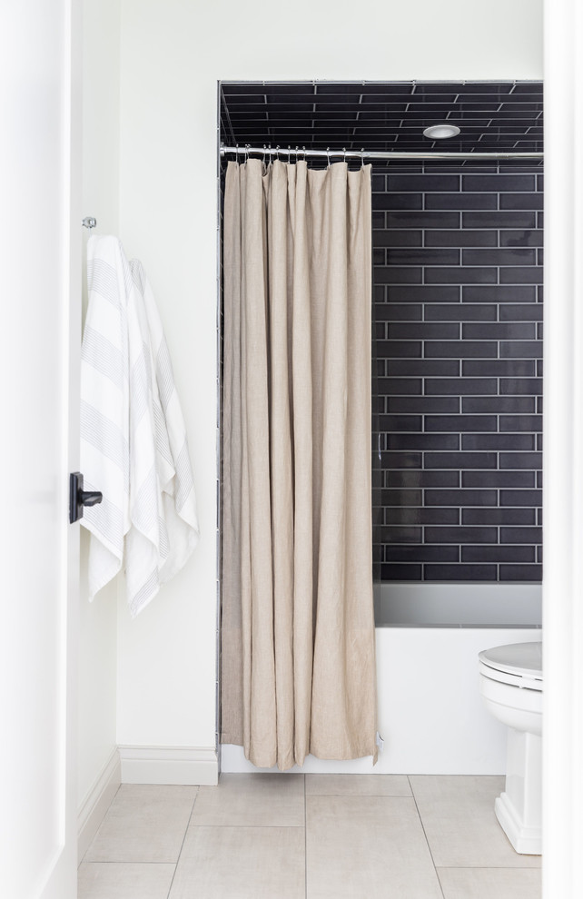 Derby House Kids Wing - New boy's en suite bathroom. Remodeled space includes new custom vanity, lighting, round grasscloth mirror, modern wall mount faucet, navy shower tile, large format floor tile, and black marble vanity top with 8" splash. Photo by Emily Kennedy Photography.