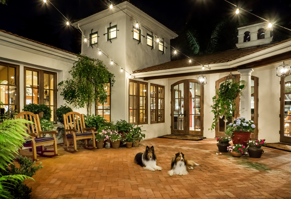 This is an example of a large mediterranean courtyard patio in San Francisco with brick pavers and no cover.