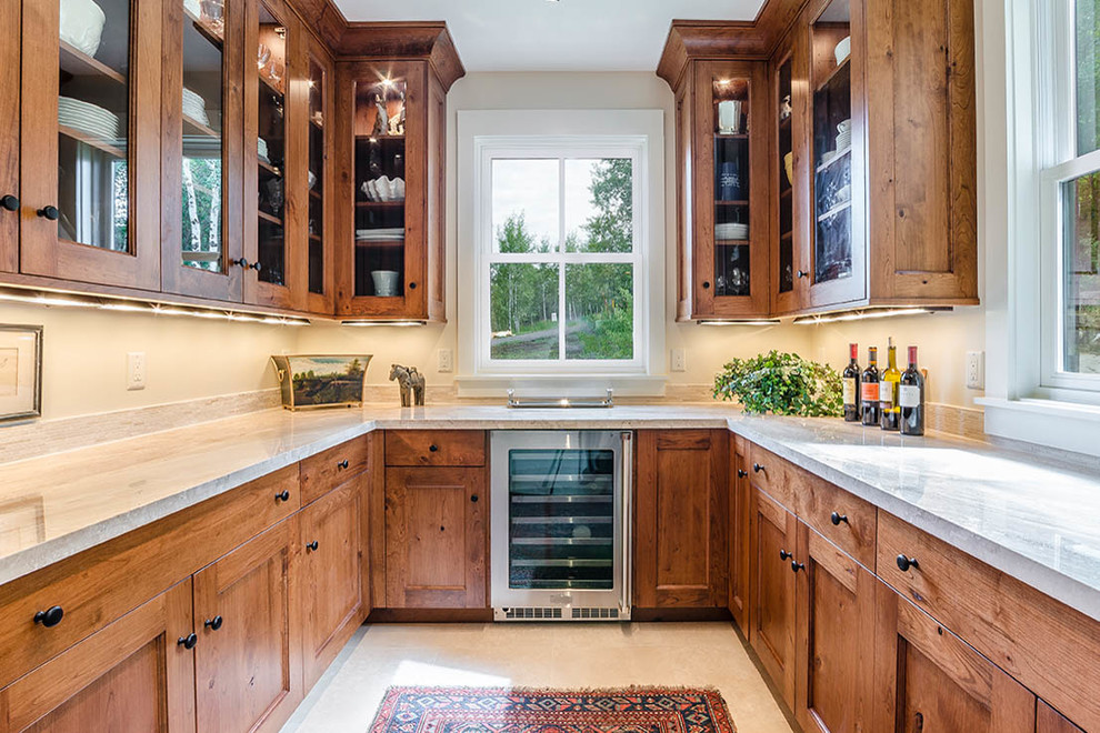 Example of a transitional u-shaped kitchen pantry design with an undermount sink, shaker cabinets, medium tone wood cabinets, marble countertops, stainless steel appliances, no island and white countertops