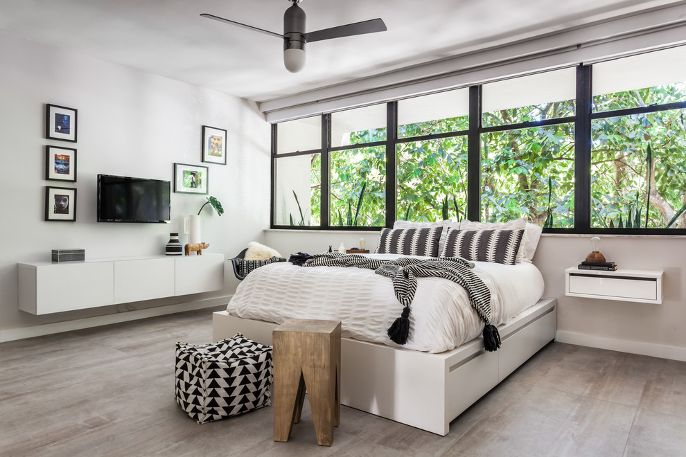 Photo of a small contemporary master bedroom in Miami with grey walls, porcelain floors and grey floor.