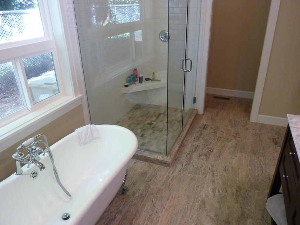 This is an example of a mid-sized contemporary master bathroom in Portland with a claw-foot tub, a corner shower, gray tile, stone tile and travertine floors.