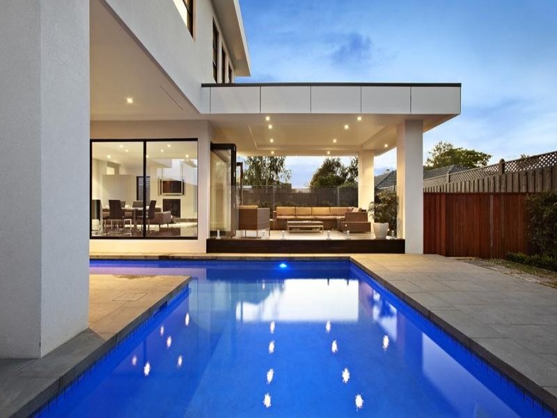 Inspiration for a mid-sized contemporary backyard l-shaped lap pool in Melbourne with natural stone pavers.