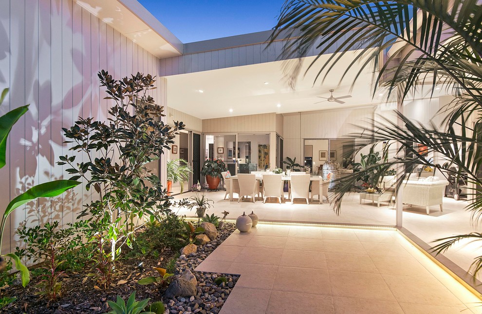 Mid-sized beach style patio in Brisbane with a roof extension.