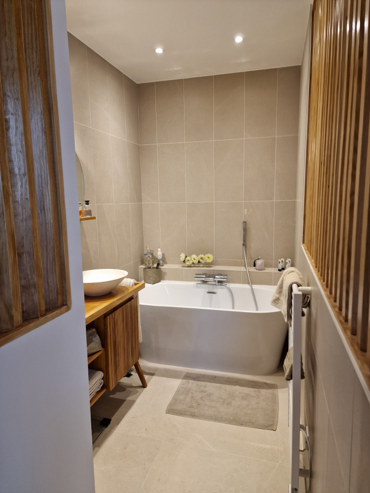 Inspiration för mellanstora klassiska brunt en-suite badrum, med ett platsbyggt badkar, en vägghängd toalettstol, beige kakel, stenkakel, beige väggar, klinkergolv i keramik, ett nedsänkt handfat, träbänkskiva och beiget golv