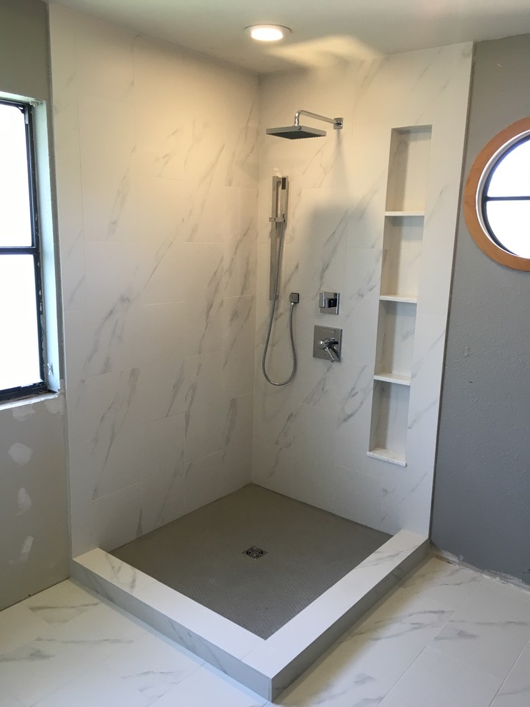 Mid-sized contemporary master bathroom in Austin with a corner shower, white tile, porcelain tile, grey walls and porcelain floors.