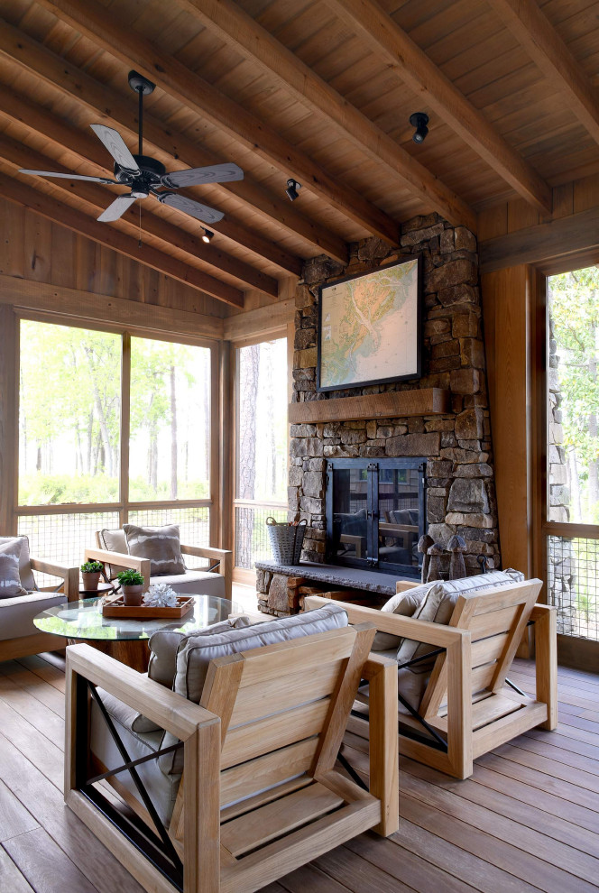 Huge mountain style metal railing porch idea in Atlanta with a fireplace and a roof extension