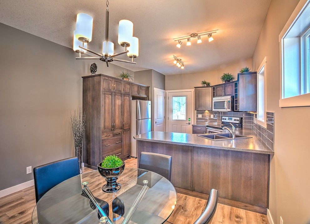 Eat-in kitchen - mid-sized transitional u-shaped medium tone wood floor eat-in kitchen idea in Calgary with shaker cabinets, medium tone wood cabinets, quartz countertops, a peninsula, a double-bowl sink, gray backsplash, ceramic backsplash and stainless steel appliances