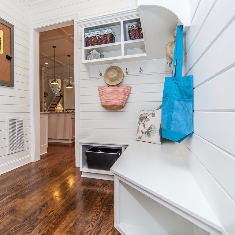 This is an example of a mid-sized country hallway in Raleigh with white walls, dark hardwood floors and brown floor.