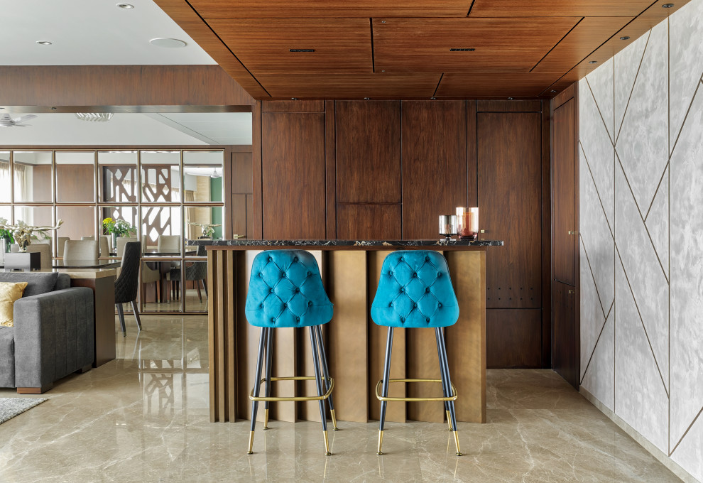 This is an example of a mid-sized contemporary single-wall seated home bar in Mumbai with flat-panel cabinets, medium wood cabinets, grey floor and grey benchtop.
