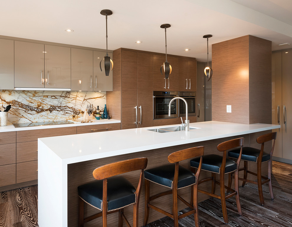 This is an example of a mid-sized contemporary u-shaped eat-in kitchen in Miami with a double-bowl sink, flat-panel cabinets, light wood cabinets, granite benchtops, brown splashback, marble splashback, stainless steel appliances, bamboo floors, with island, brown floor and brown benchtop.