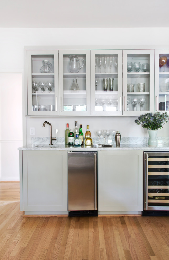 Design ideas for a transitional home bar in Austin with glass-front cabinets and grey cabinets.