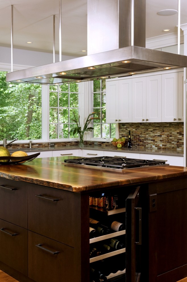 Enclosed kitchen - mid-sized transitional u-shaped medium tone wood floor and brown floor enclosed kitchen idea in DC Metro with an undermount sink, shaker cabinets, white cabinets, brown backsplash, glass tile backsplash, stainless steel appliances and an island