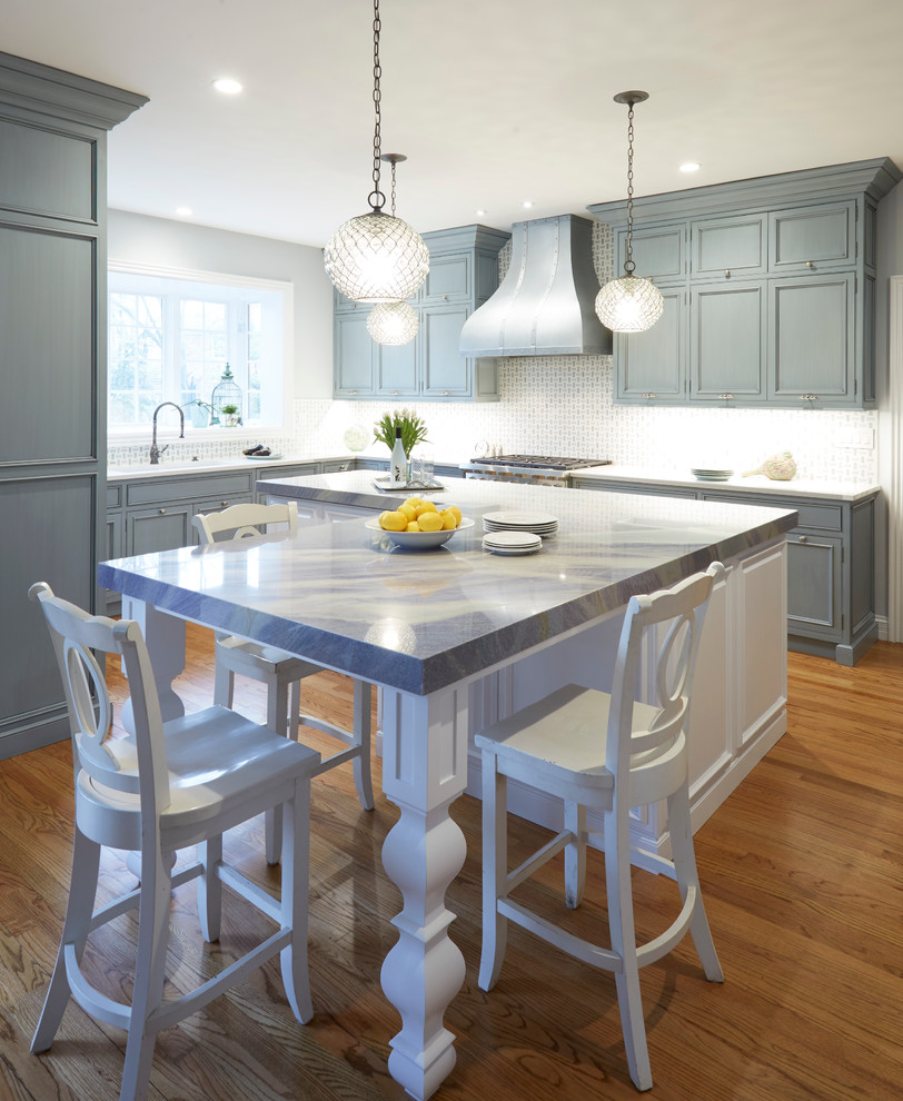 Traditional l-shaped eat-in kitchen in Chicago with beaded inset cabinets, blue cabinets, quartzite benchtops, blue splashback, stone tile splashback, panelled appliances, light hardwood floors and with island.