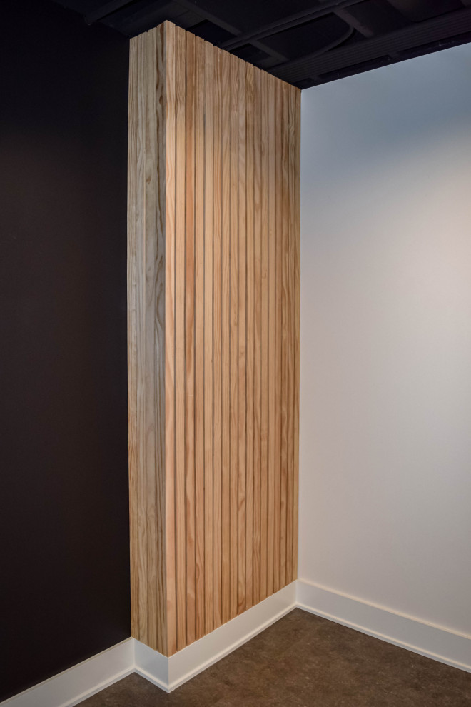 Modernes Untergeschoss mit schwarzer Wandfarbe, Laminat und schwarzem Boden in Chicago