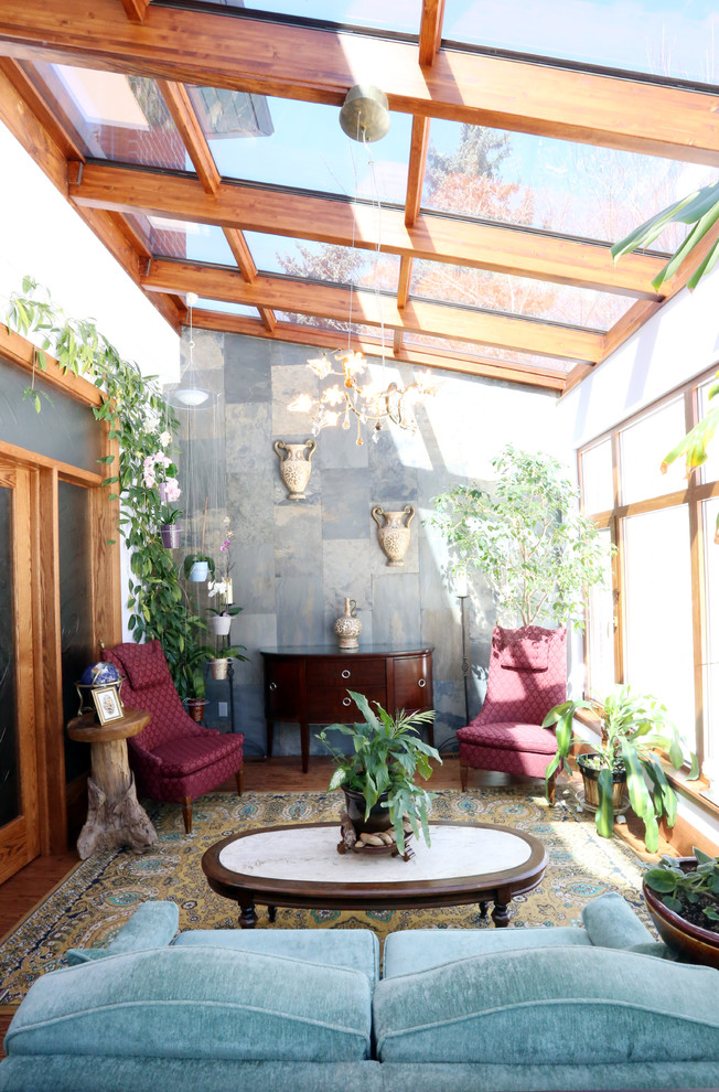 This is an example of a traditional sunroom in Toronto with medium hardwood floors and a glass ceiling.
