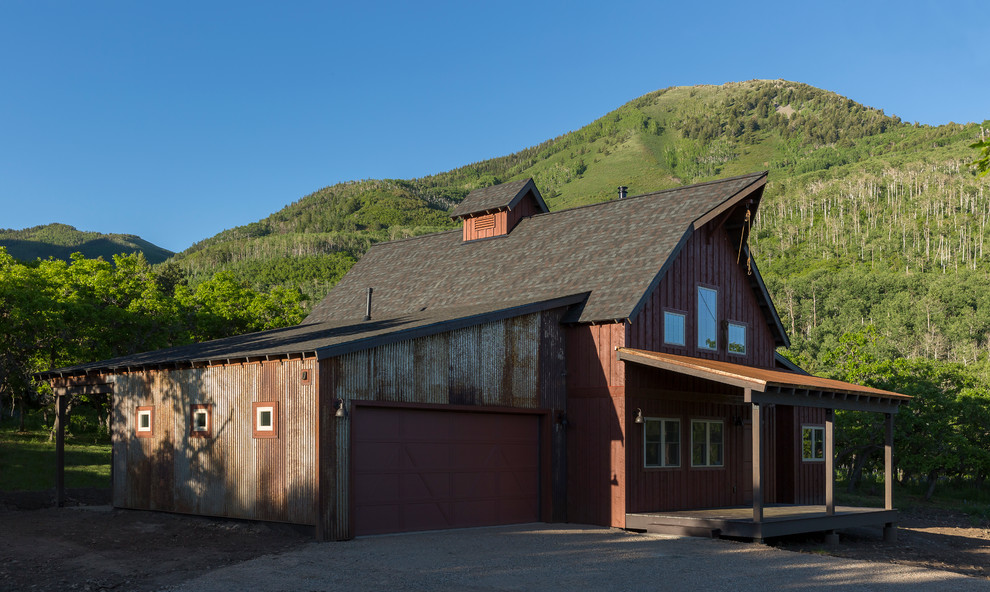 Photo of a mid-sized country two-storey red exterior in Albuquerque with metal siding.