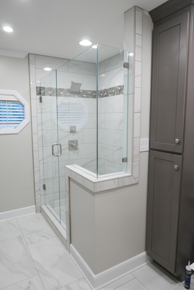 Photo of a mid-sized transitional master bathroom in Other with shaker cabinets, grey cabinets, an alcove shower, a two-piece toilet, white tile, porcelain tile, grey walls, porcelain floors, an undermount sink, engineered quartz benchtops, white floor, a hinged shower door and multi-coloured benchtops.