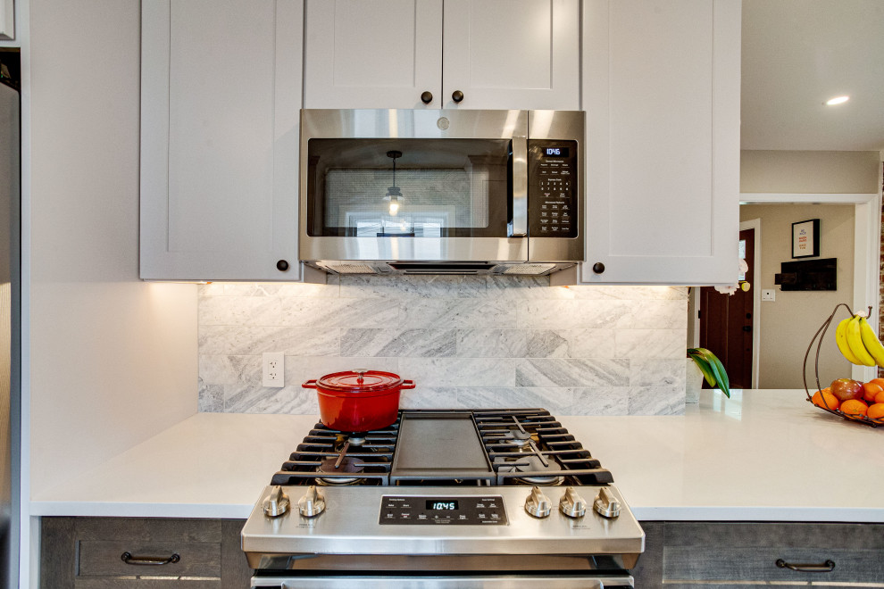 Small transitional single-wall kitchen photo in DC Metro with a farmhouse sink, quartz countertops, stainless steel appliances and a peninsula